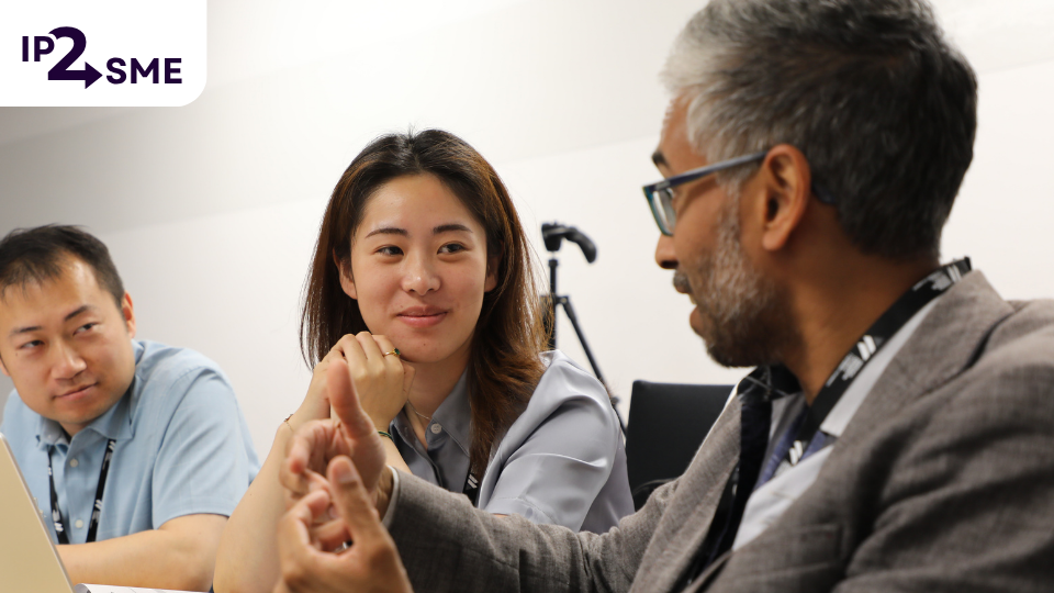 Three people in business atire having an informal discussion at a table.